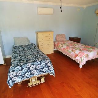 A bedroom with two single beds and wooden flooring.
