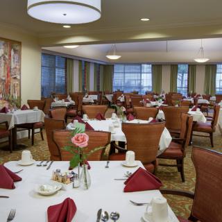An elegantly set dining room with tables and chairs, ready for guests.