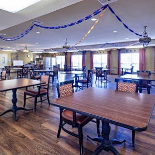 A spacious dining area featuring multiple tables and decorative streamers.
