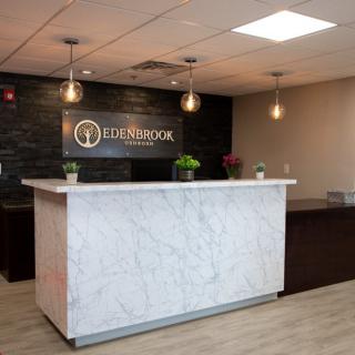 A modern office reception area with a marble counter and stylish lighting.