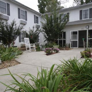 A peaceful residential building with a landscaped garden and patio.