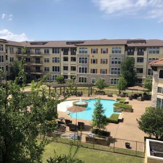 An apartment complex with a central swimming pool and landscaped outdoor area.