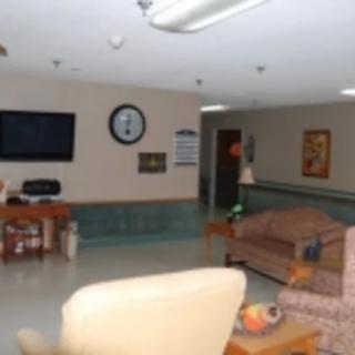 A cozy lounge area featuring sofas, a TV, and a clock on the wall.