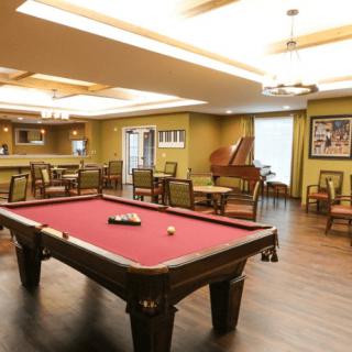 A cozy game room featuring a billiards table and bar area.