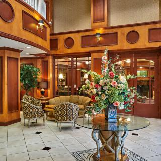 An elegant hotel lobby with stylish furniture and floral decorations.