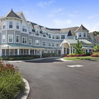A large, picturesque building with Victorian-style architecture and manicured gardens.