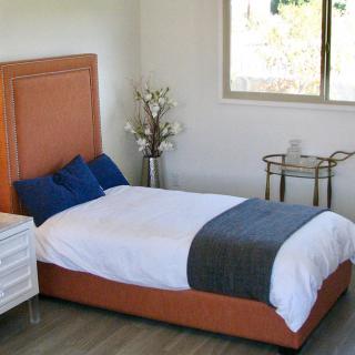 A neatly arranged bedroom with a bed, pillows, and modern decor.