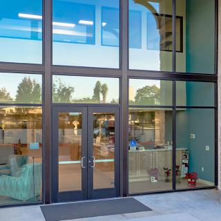 A modern building entrance with large glass windows and doors.