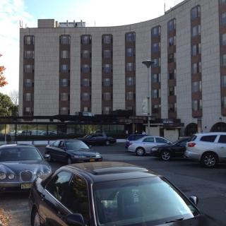 A hotel building with a parking lot filled with cars.