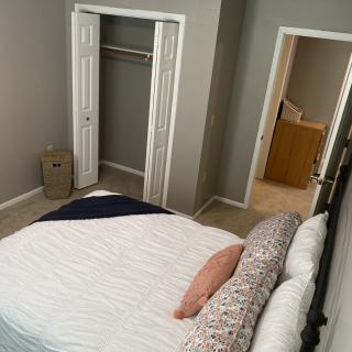 Cozy bedroom with a neatly made bed and open closet.