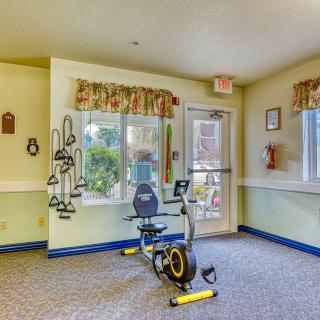 A small exercise room with a stationary bike and bright natural lighting.