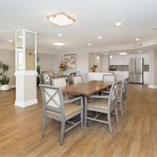 A modern dining room with wood flooring and elegant furniture in an open, well-lit space.