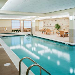 A serene indoor swimming pool area with seating and decor.