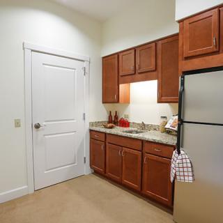 A modern kitchen with wooden cabinets, stainless steel appliances, and a spacious countertop.