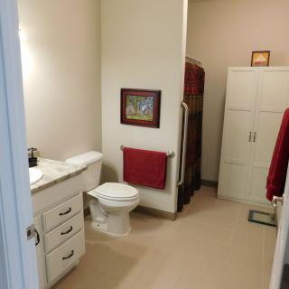 A modern bathroom with a toilet, sink, and storage cabinet.
