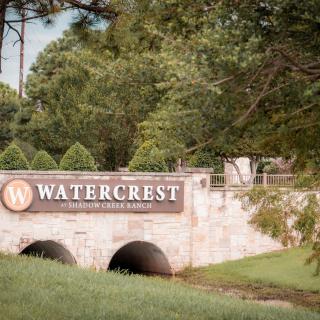 Entrance sign for Watercrest set against a lush, green landscape.