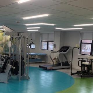 A well-equipped gym featuring various exercise machines and a vibrant floor design.