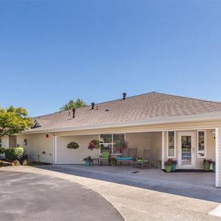 A single-story residential house with a driveway and landscaped entrance.
