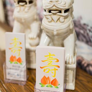 Ceramic guardian lion statues with decorative cards featuring Chinese characters and peach motifs.