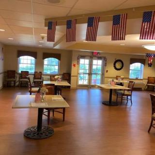A spacious dining area decorated with American flags, featuring multiple tables and chairs.