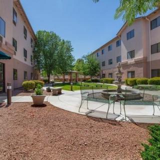 A peaceful courtyard with seating areas surrounded by buildings and greenery.
