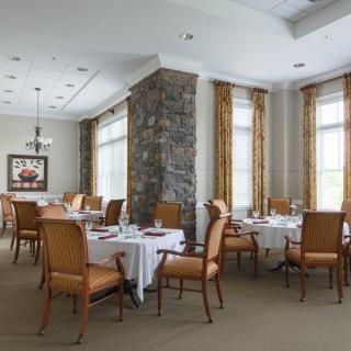 A well-lit restaurant dining area featuring neatly arranged tables and chairs.