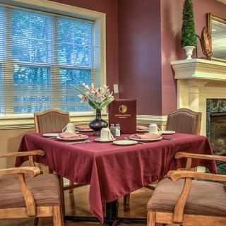 An elegant dining room with a beautifully set table near a cozy fireplace.