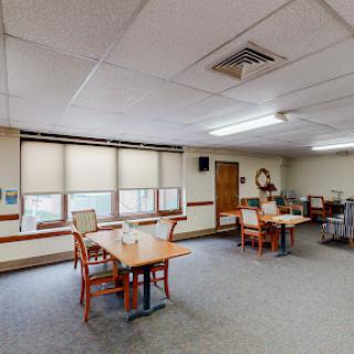 A spacious dining area featuring wooden tables and chairs, designed for communal gatherings.