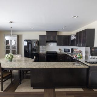 A modern kitchen with dark cabinetry and a spacious island.