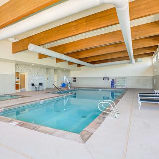 An indoor swimming pool featuring seating and modern architectural design.