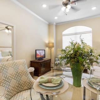 A cozy living room with an elegant dining area, featuring a floral centerpiece and tasteful decor.