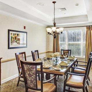 An elegant dining room with a set table and chandelier.