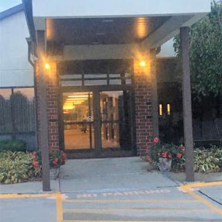 An inviting entrance of a modern building illuminated in the evening light.