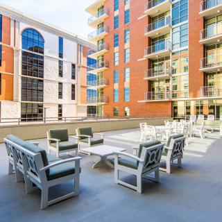 A modern apartment complex with outdoor seating and a spacious patio area.