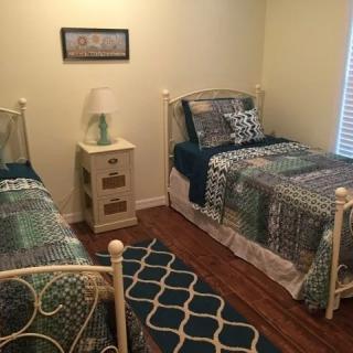A cozy bedroom with two twin beds, a nightstand, and decorative elements.