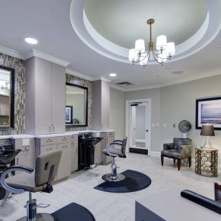 A modern salon interior with elegant styling chairs and a stylish chandelier.