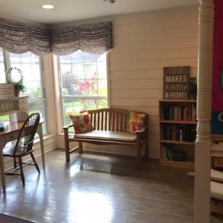 Bright and cozy living room with a bench and bookshelf.