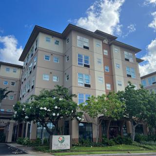 A modern residential apartment building under a partly cloudy sky.