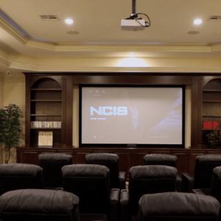 A cozy home theater setup with comfortable seating and a large projector screen.