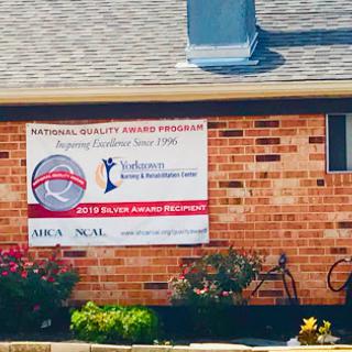 A banner promoting a national quality award hangs on the exterior of a brick building.