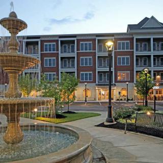 A beautiful fountain graces the front of a modern building in the evening light.