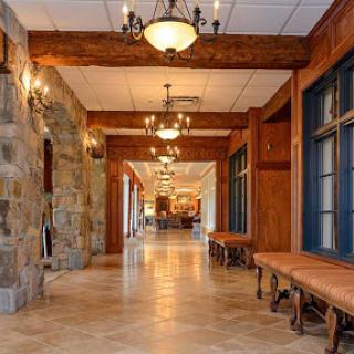 A beautifully designed hallway featuring wooden beams, stone walls, and elegant lighting.