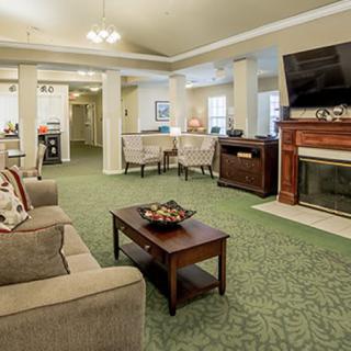 A cozy living room with a comfortable sofa, coffee table, fireplace, and television.