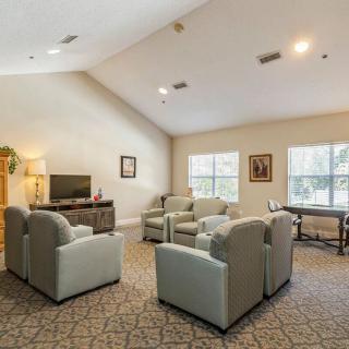 A cozy living room with comfortable seating, a television, and natural light from windows.