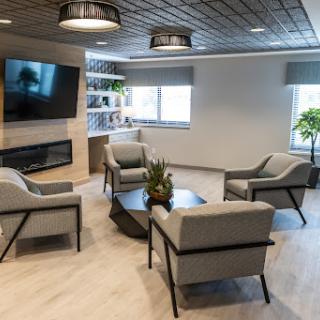 A modern living room setup featuring comfortable seating, a television, and decorative plants.