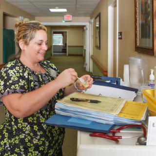 A healthcare worker organizes medication and paperwork in a hospital setting.