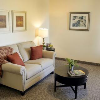 A cozy living room with a sofa, coffee table, and decorative artwork.