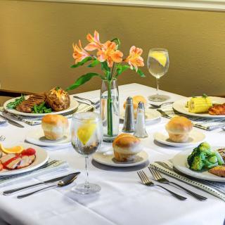 A beautifully set dining table with elegant dinnerware and floral centerpiece.