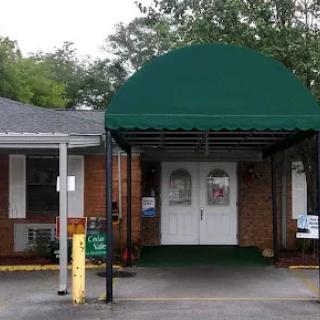 A small brick building with a green awning over the entrance.