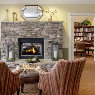 A cozy living room with a stone fireplace and comfortable seating.